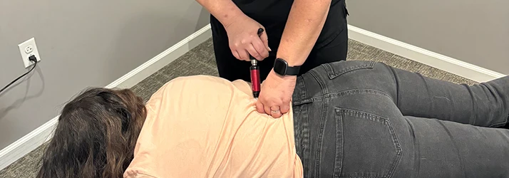 Chiropractor Eureka MO Abby Painter With A Patient Chiropractor Abby Painter using the activator technique on a patient.