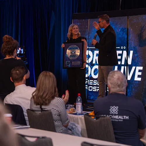 Chiropractor Eureka MO Ashley Brunjes Driven Doc Award 1 Dr. Ashley Brunjes with the driven doc award on stage.
