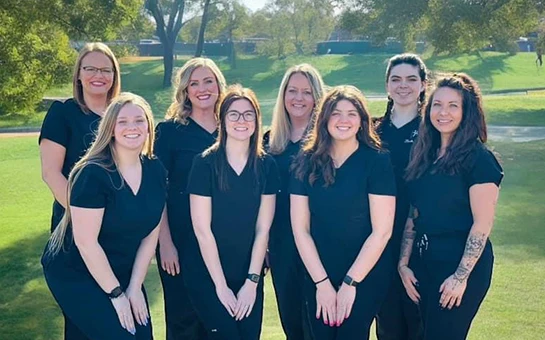 Chiropractor West St. Louis MO Ashley Brunjes And Abby Painter And Jessica Ferguson With Team Ashley Brunjes D.C., Abby Painter D.C., and Jessica Ferguson D.C. outside smiling with their team.