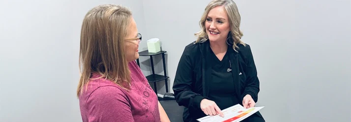 Chiropractor West St. Louis MO Ashley Brunjes Patient Consultation Dr. Ashley Brunjes giving a patient consultation.